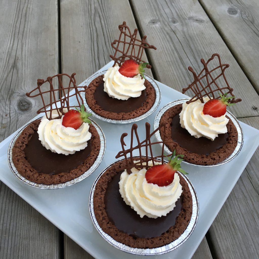 Kladdkaksmuffins med chokladkolakräm och grädde toppade med jordgubbar